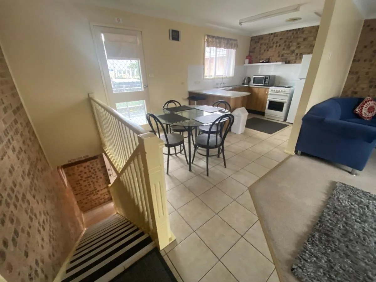 Inside a split-level apartment: stairs, a dining table and a full kitchen